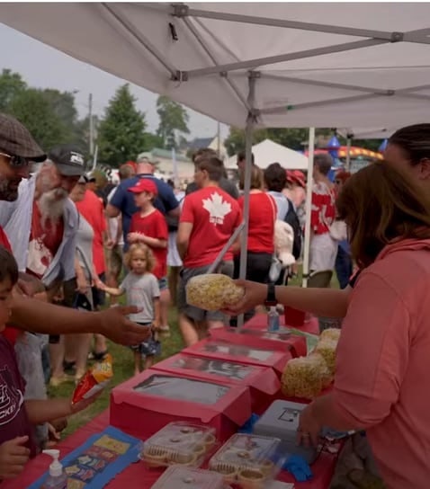Norpak staff serving at a community barbecue tent